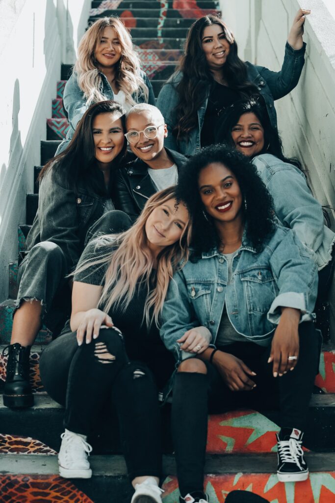 Group of multi racial women sitting on stairs, celebrating eating disorder recovery