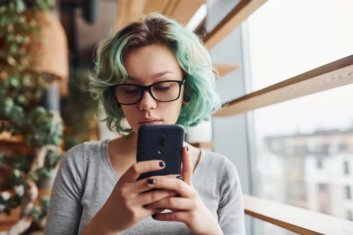 Girl looking for weight inclusive eating disorder treatment on a cell phone.